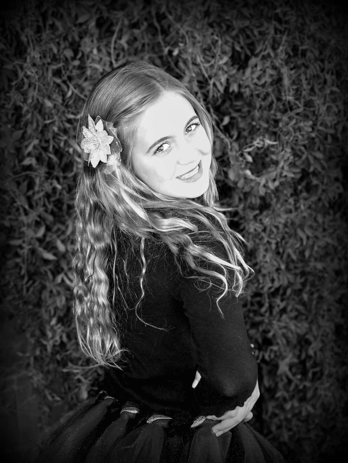 Black and white portrait of Lexi Schultz smiling over her shoulder